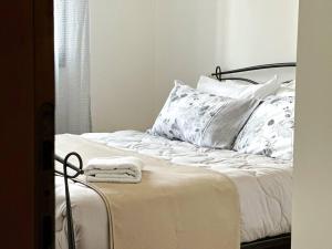 a bedroom with a bed with white sheets and pillows at a due passi da Conegliano in Capo di Sotto