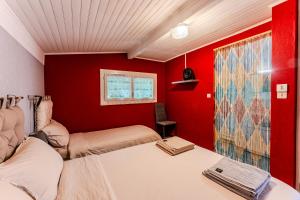 a bedroom with two beds and a red wall at Villa Eva in Biscarrosse-Plage