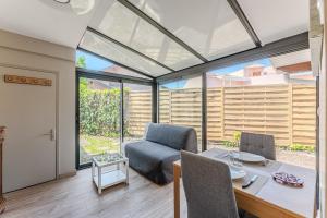 a living room with a table and a chair at Villa Eva in Biscarrosse-Plage