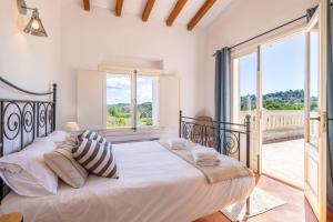 a bedroom with a large bed and a balcony at Casa de los Almendros in El Port de la Selva +37 photos