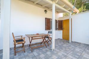 a patio with a wooden table and chairs on a house at Captain Spiros Picola in Gaios