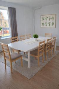 a dining room table with chairs and a white table at Maria Isabelles boende nr 3 in Fjugesta +1 photo