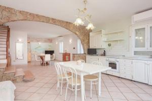 a kitchen with a white table and a dining room at Villa Alfredo Golfo Aranci in Golfo Aranci