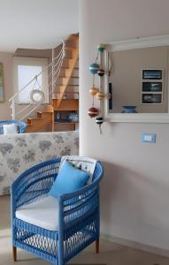 a blue chair in a living room with a staircase at Villa Bella Vista in Zambrone