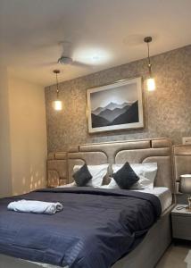 a bedroom with a large bed with blue sheets and pillows at The Bloomhouse inn in Rājpur