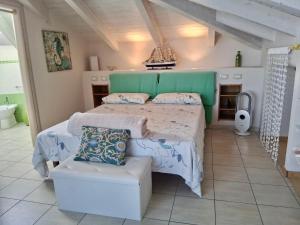 a bedroom with a large bed and a chair at Villa Bella Vista in Zambrone