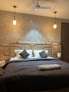a bedroom with a large bed with blue pillows at The Bloomhouse inn in Rājpur +2 photos