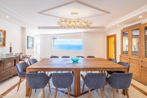 a dining room with a large wooden table and chairs at Villa Juan Carlos in Cala Vinyes