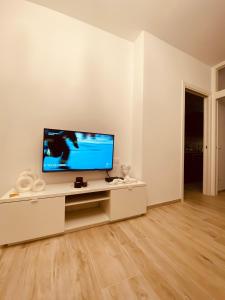 a white living room with a flat screen tv on a table at A Vernazza La Conchiglia Doro in Vernazza