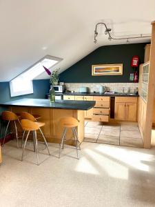 a kitchen with a large island with stools in it at The Ormond Apartments in Dungarvan