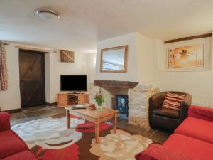 a living room with a red couch and a fireplace at Cider Cottage - near Lyme Regis in Axminster