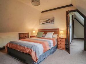 a bedroom with a bed with two lamps and a door at Cider Cottage - near Lyme Regis in Axminster