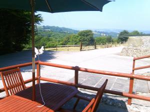 a chair and an umbrella on a balcony at Cider Cottage - near Lyme Regis in Axminster