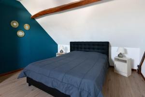 a bedroom with a bed with a blue blanket at Gite Les Salicornes in Lanchères