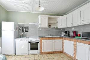a kitchen with white cabinets and a white refrigerator at Gite Les Salicornes in Lanchères