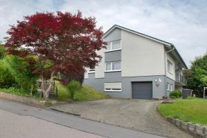 a white house with a garage on a street at Ferienwohnung Hofer in Kalkofen