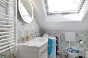 a bathroom with a sink and a toilet and a window at Ferienwohnung Hofer in Kalkofen +19 photos