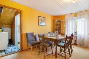 a dining room with a wooden table and chairs at Ferienwohnung Hofer in Kalkofen