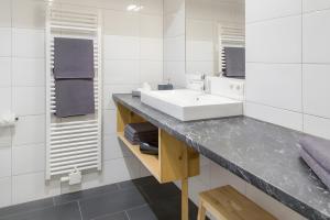a white bathroom with a sink and a mirror at Appartement Moosmann in Mellau