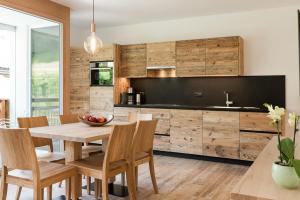 a kitchen with wooden cabinets and a wooden table and chairs at Natur Suite Edelweisshof App Heidi in Chiusa +10 photos