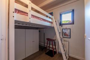 a bunk bed in a room with a ladder and a stool at Appartement Les Cezares in Les Allues