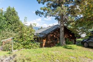 a wooden cabin with a tree next to it at Appartement Les Cezares in Les Allues