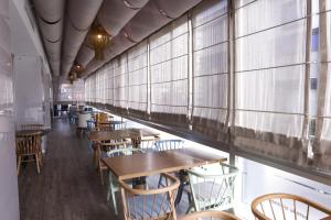 a row of tables and chairs in a restaurant with windows at Hampton By Hilton Gaziantep in Gaziantep