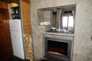 a fireplace in a kitchen with a sink and a window at Chalet d' Egloo 10-12 pers in Samoëns