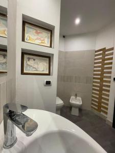 ein Badezimmer mit einem weißen Waschbecken und einer Toilette in der Unterkunft Valle Benedetta in Stagno