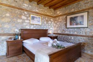 a bedroom with a bed in a stone wall at Villa Lazar in Lefkada