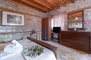 a bedroom with a bed and a dresser and a television at Villa Lazar in Lefkada