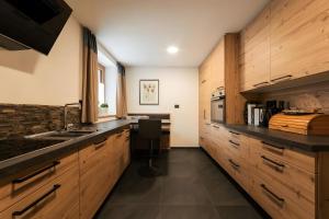a kitchen with wooden cabinets and a sink at Ciasa Ilda - Charming House 120 M2 in La Valle +8 photos