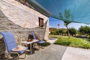 a stone house with a table and two chairs at Villa Lazar in Lefkada