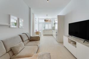 a living room with a couch and a flat screen tv at Serenity in Arona