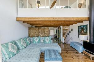 a living room with a blue couch and a tv at Designer House With Panoramic views in Cadaqués