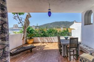 a patio with a table and chairs and an umbrella at Designer House With Panoramic views in Cadaqués