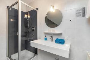 a white bathroom with a sink and a shower at Haus Sum in Oberwolfach +26 photos