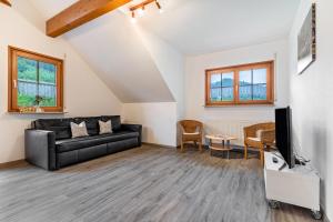 a living room with a couch and a tv at Haus Sum in Oberwolfach