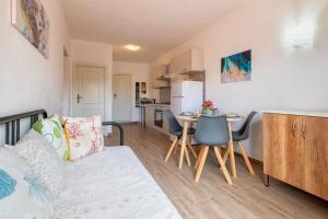 a living room with a couch and a table and a kitchen at Endless Summer Apartment in Isola Rossa
