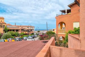 a city street with cars parked in a parking lot at Endless Summer Apartment in Isola Rossa