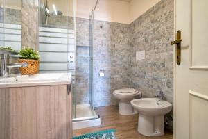 a bathroom with a toilet and a sink and a shower at Endless Summer Apartment in Isola Rossa +10 photos
