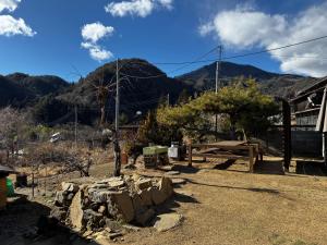 Blick auf einen Bauernhof mit Bergen im Hintergrund in der Unterkunft MEKIKI古民家 yorimichi in Yamanashi