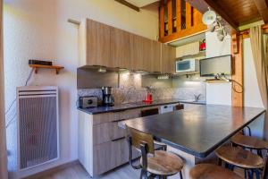 a kitchen with a table and some chairs in it at Appartement Manigod Merdassier 8 p in Manigod +14 photos