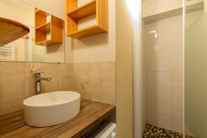 a bathroom with a white sink on a wooden counter at Appartement Manigod Merdassier 8 p in Manigod