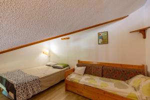 a room with two beds in a room with a bedskirts at Appartement Manigod Merdassier 8 p in Manigod