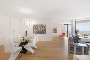 a dining room and living room with a table and chairs at Mare Nostrum in Olhão