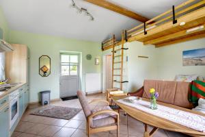 a living room with a table and a couch at Apartment Eulenhof 1 in Bordelum +13 photos