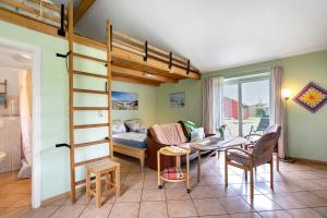 a living room with a loft bed and a dining room at Apartment Eulenhof 1 in Bordelum