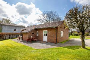 a small brick house with a picnic table in a yard at Apartment Eulenhof 1 in Bordelum