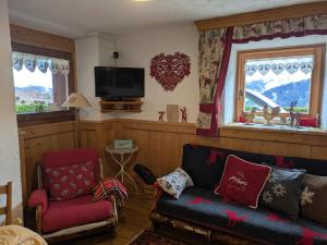 a living room with a couch and a tv at Baita Nido tra i Monti in Daone
